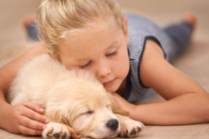 Cute kid sleeping with her puppy